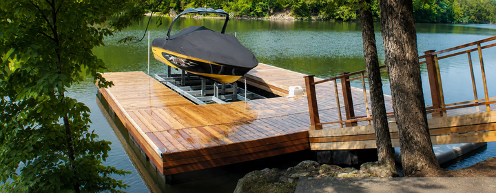 Explore Our Services Workers installing wooden decking on a lakeside dock under a sunny blue sky