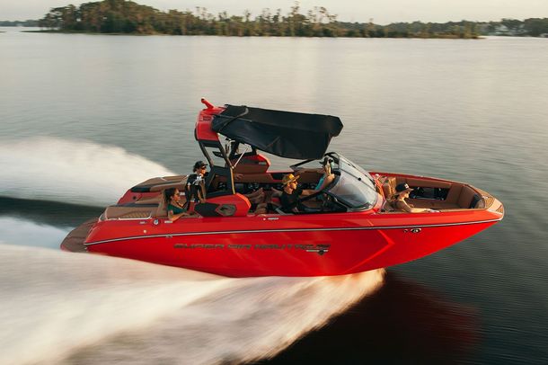 Red speedboat racing across calm water, leaving a white wake behind it