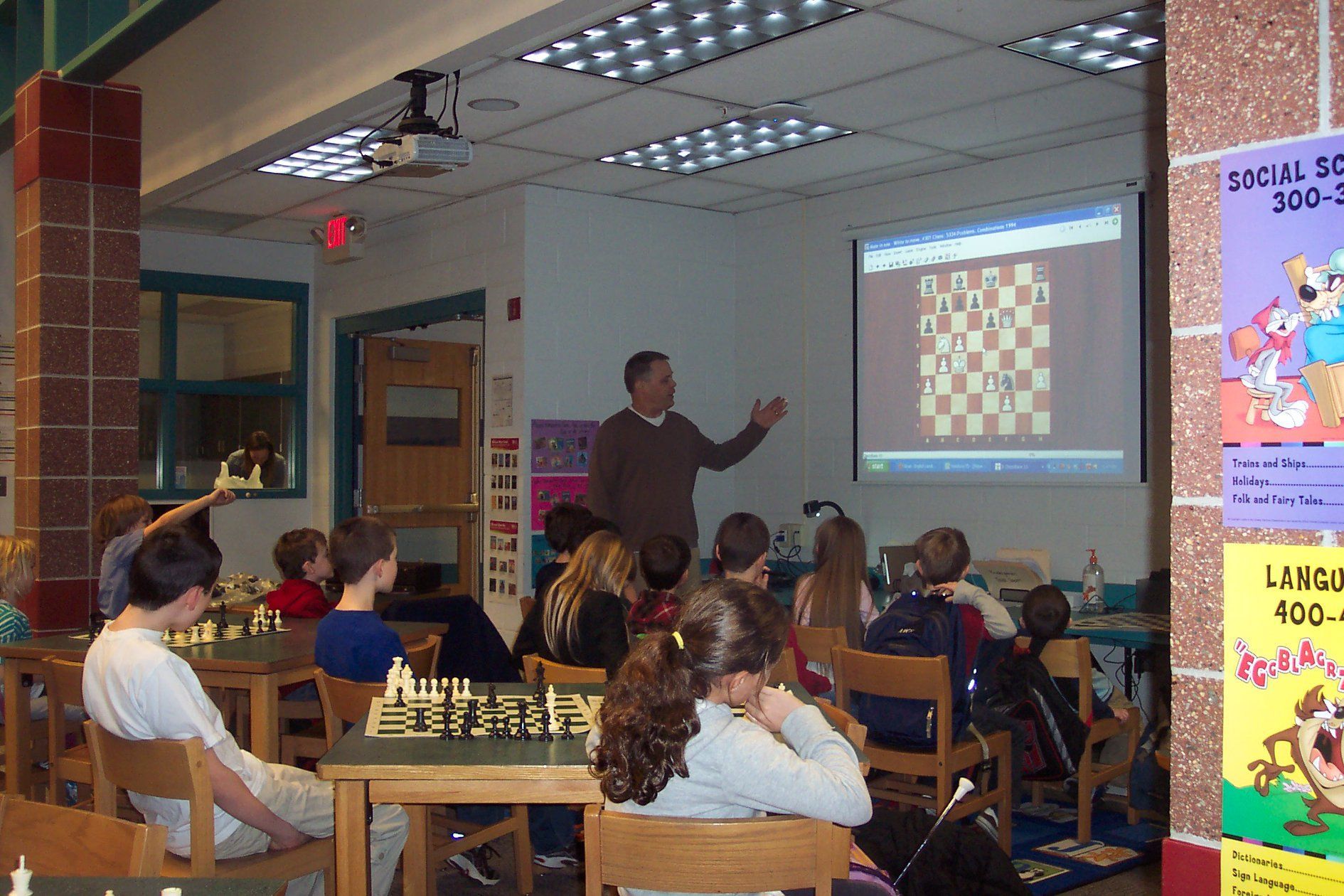 A man is giving a presentation on chess to a group of children