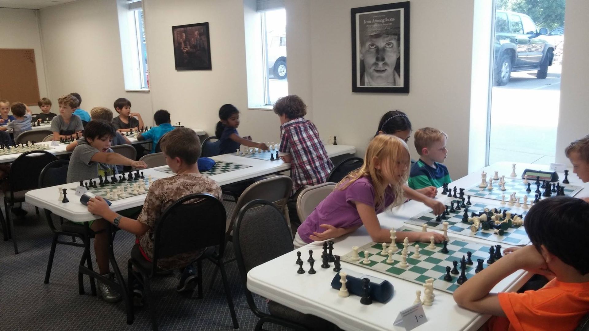 A group of children are playing chess in a room.