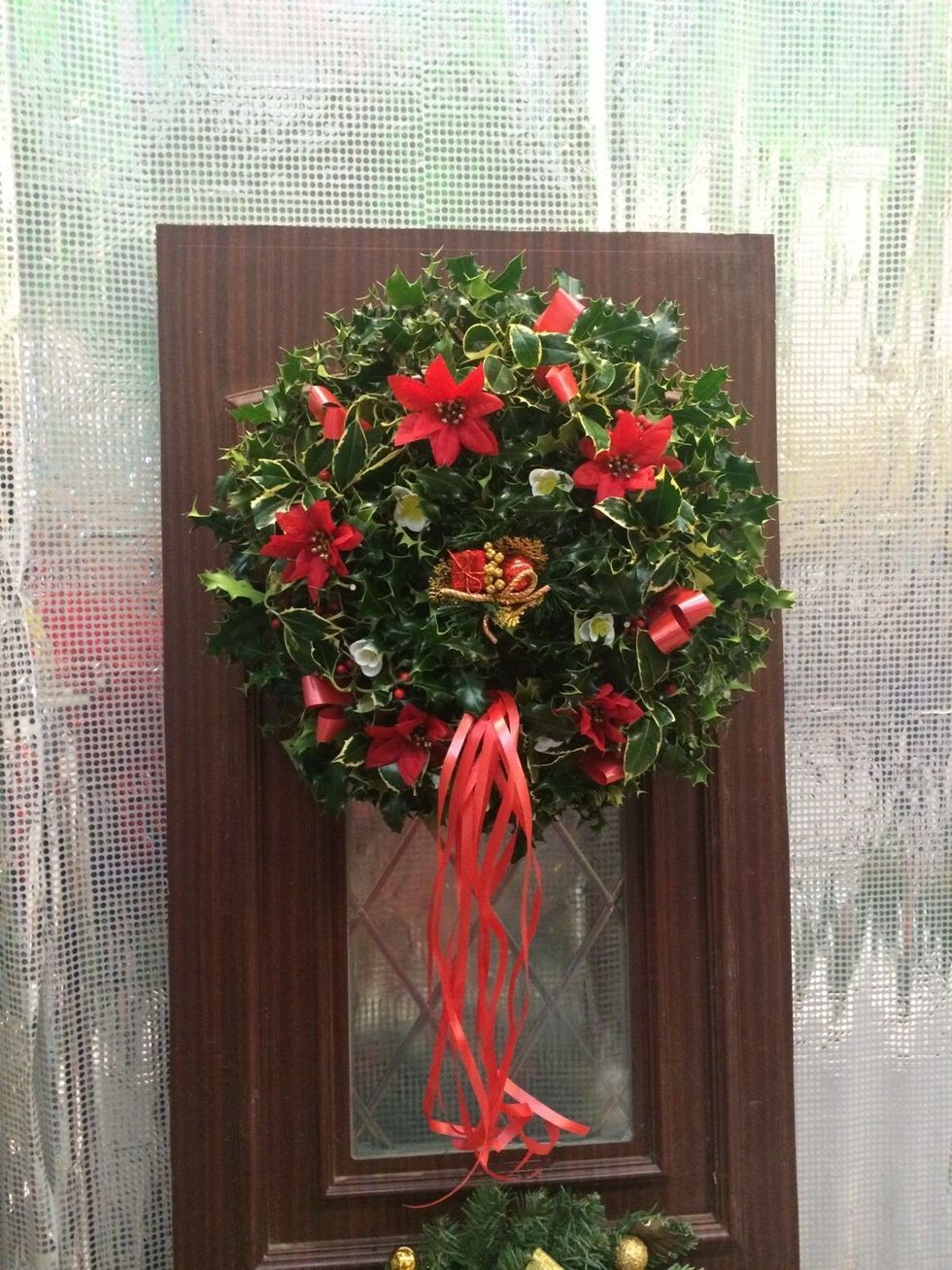 Christmas wreath with decorative red flowers and bows