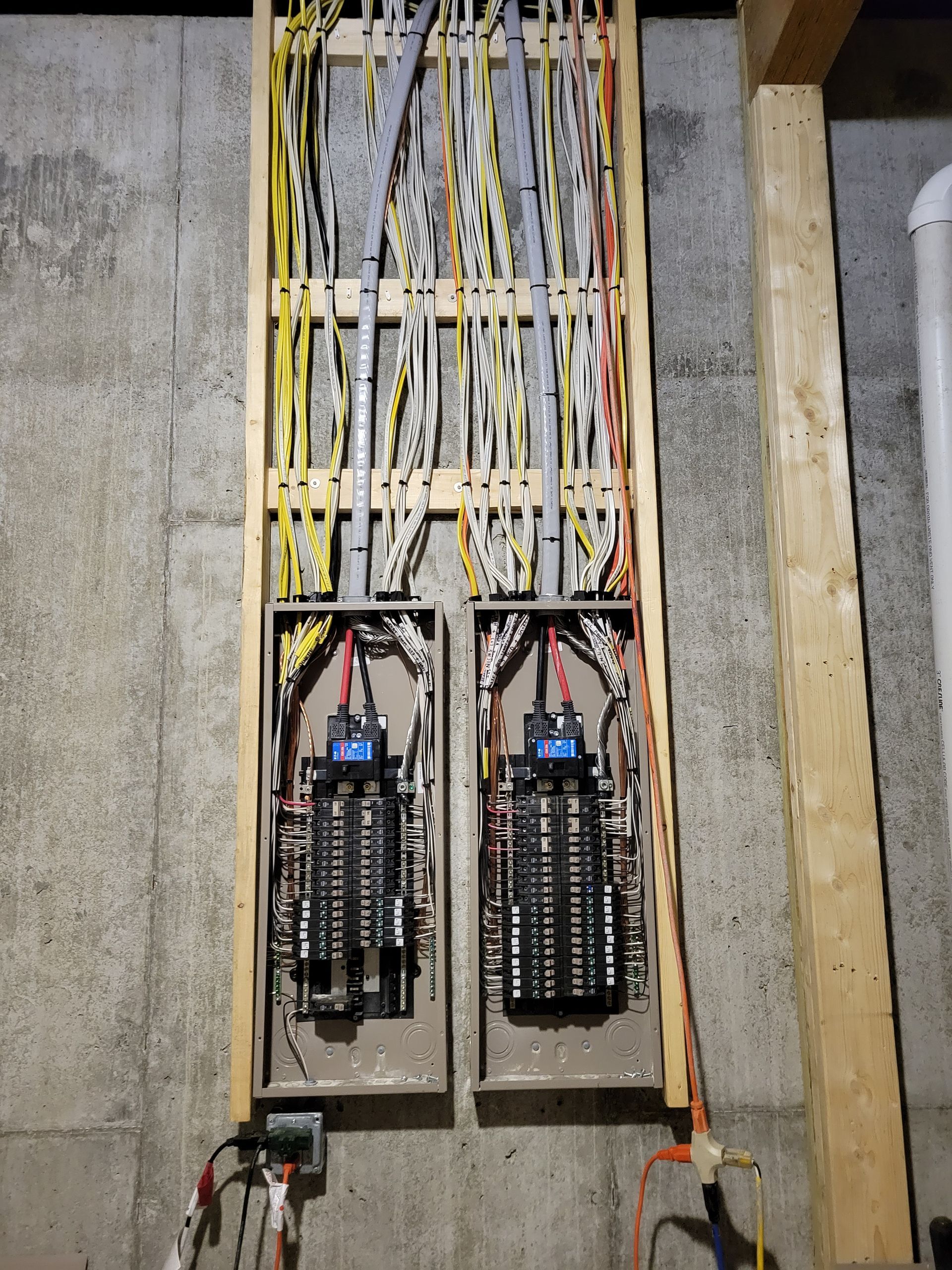 Electrician installing a square ceiling light in a modern home, standing on a step ladder.