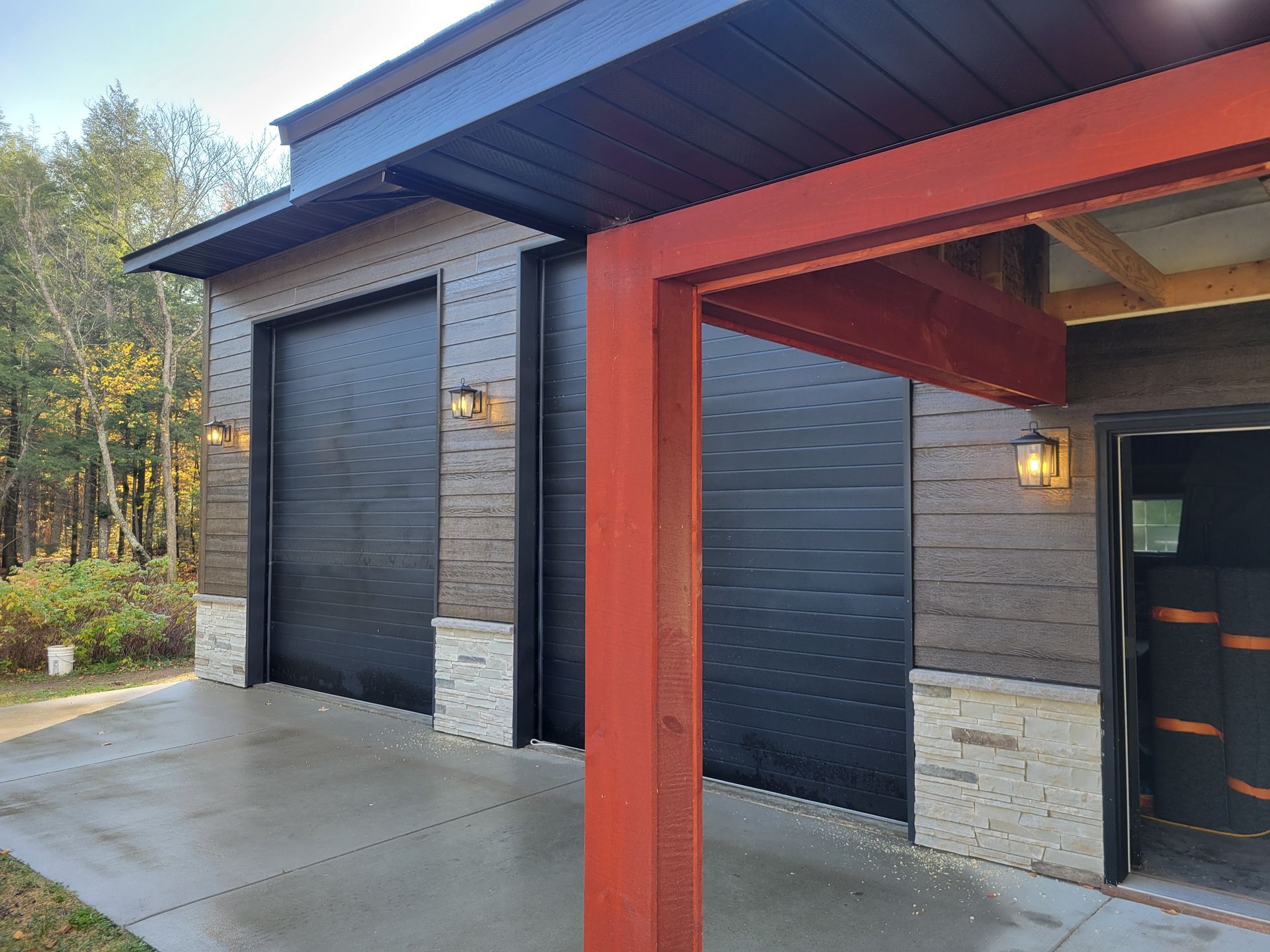 Electrician in yellow hard hat examining electrical panel, holding clipboard and tool.