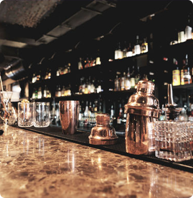 A bar with a lot of glasses and shakers on it