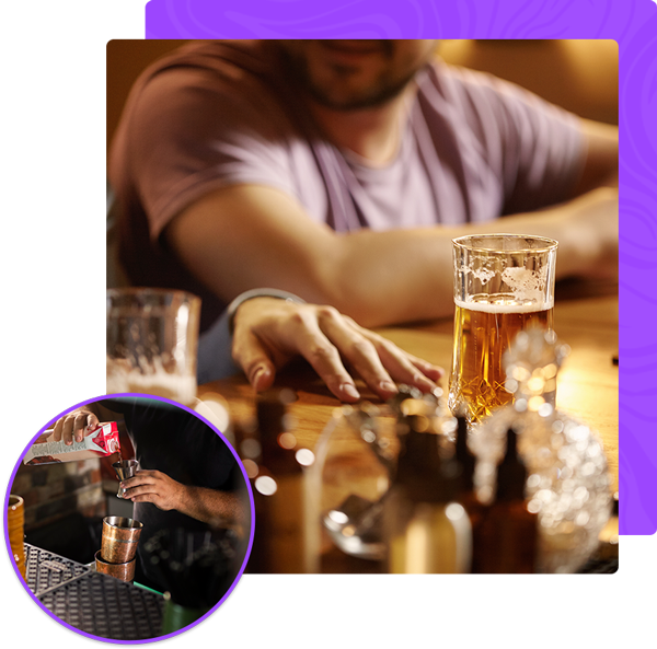 A man sitting at a table with a glass of beer in front of him