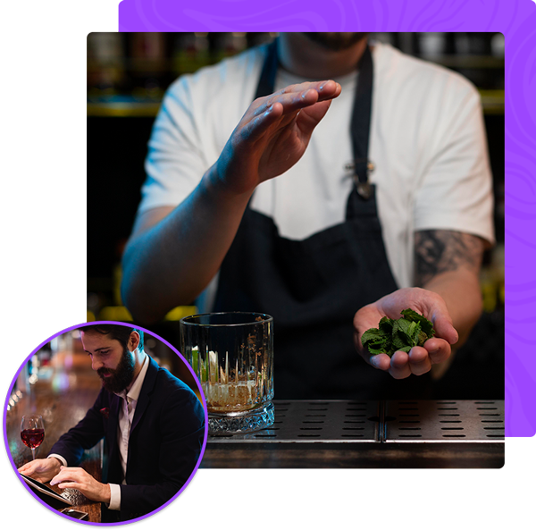 A man in an apron is holding a glass of whiskey