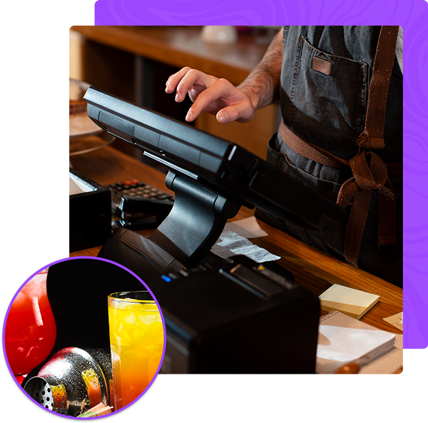 A man is typing on a computer next to a glass of orange juice