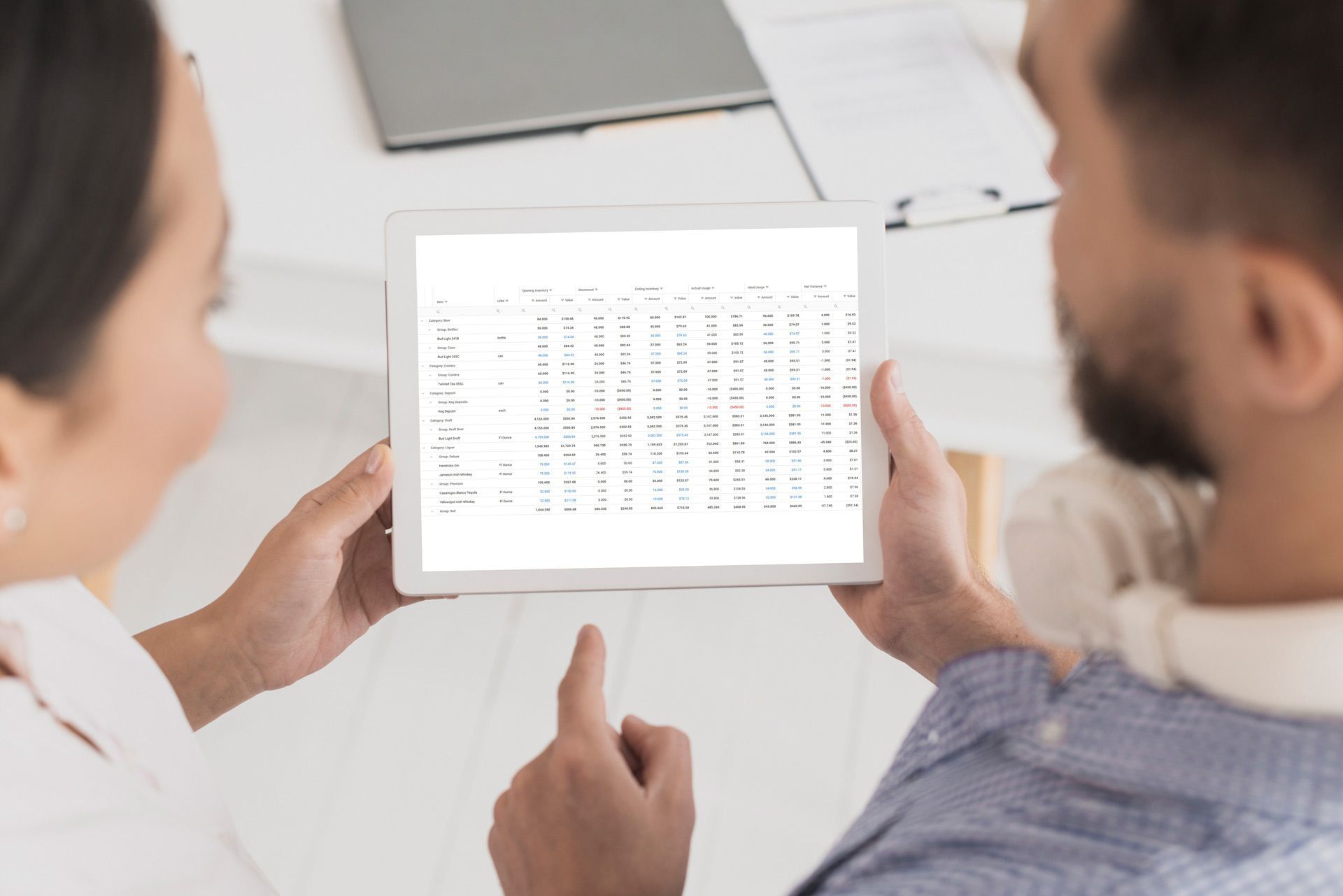A man and a woman are looking at a tablet computer.
