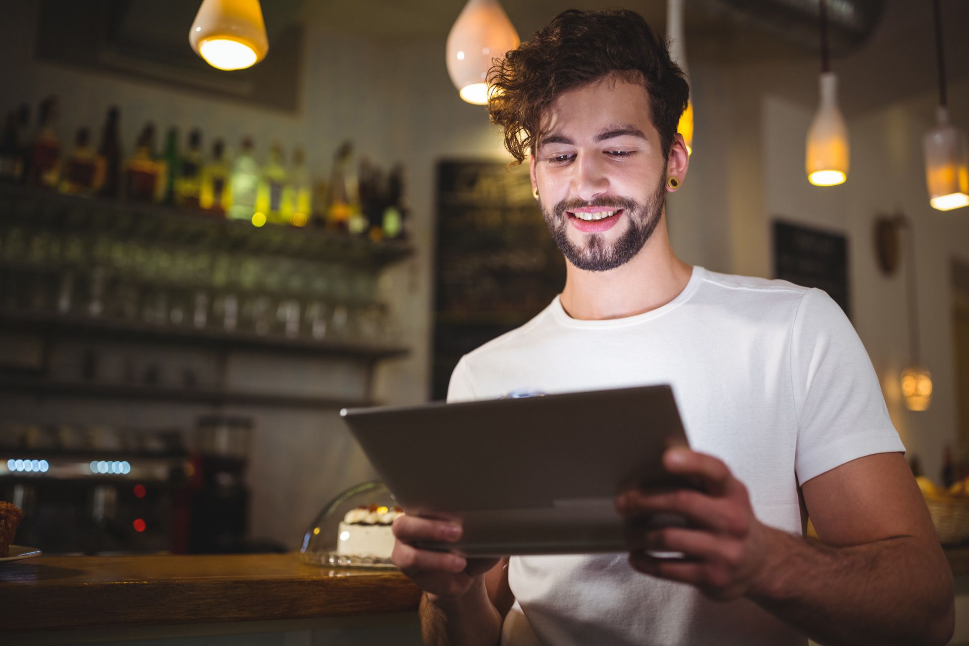 A man is using a tablet computer in a restaurant.