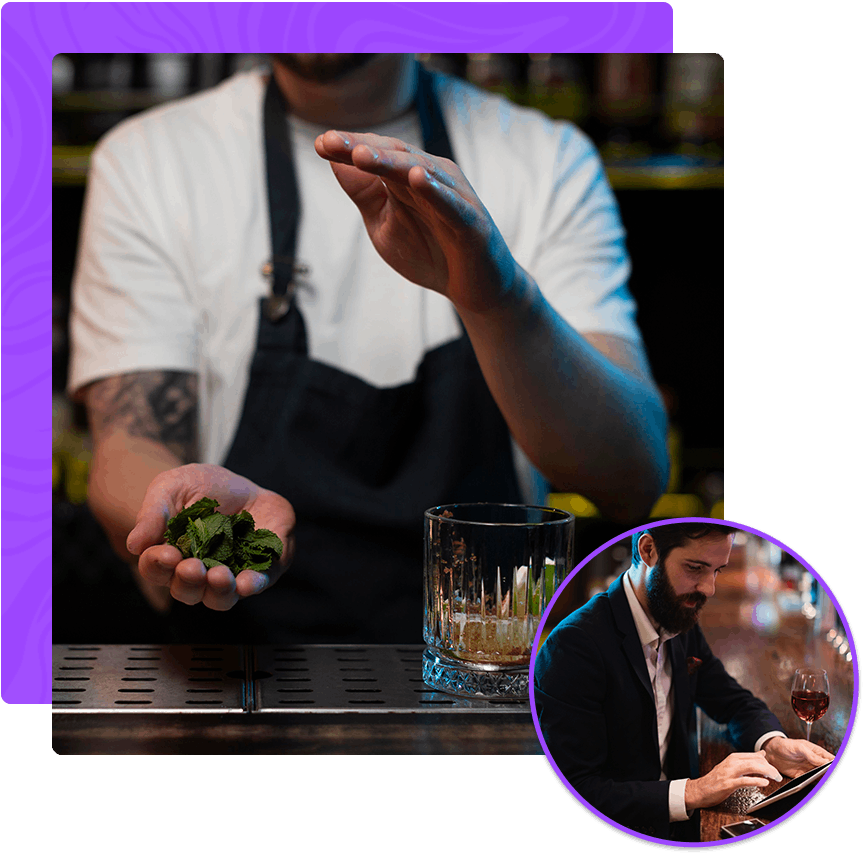 A bartender is holding a handful of greens next to a glass of whiskey.