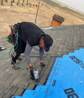 A truck is loading roofing materials into a house