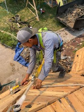 A group of construction workers are working on a roof.