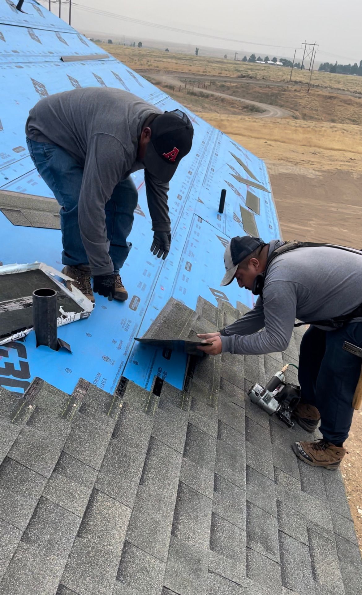 A man is installing shingles on a roof.