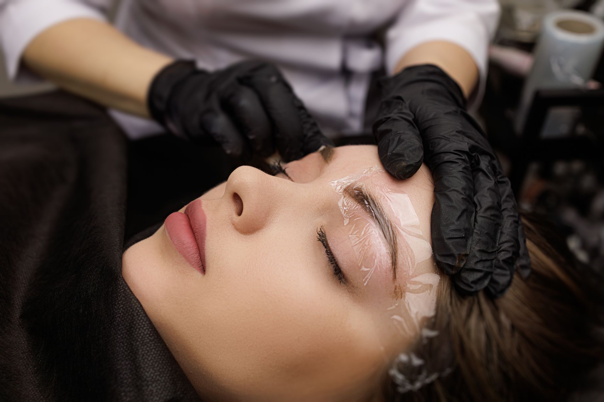 A woman is getting her eyebrows done in a beauty salon.