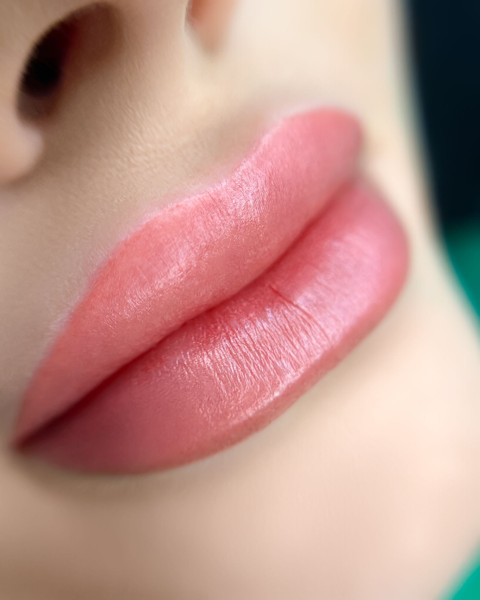 A close up of a woman 's lips with pink lipstick.