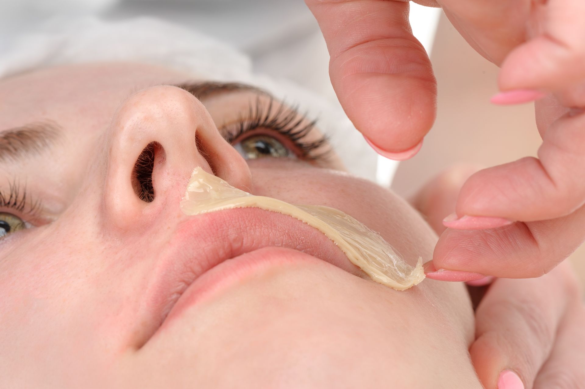 A woman is getting her face waxed at a beauty salon.