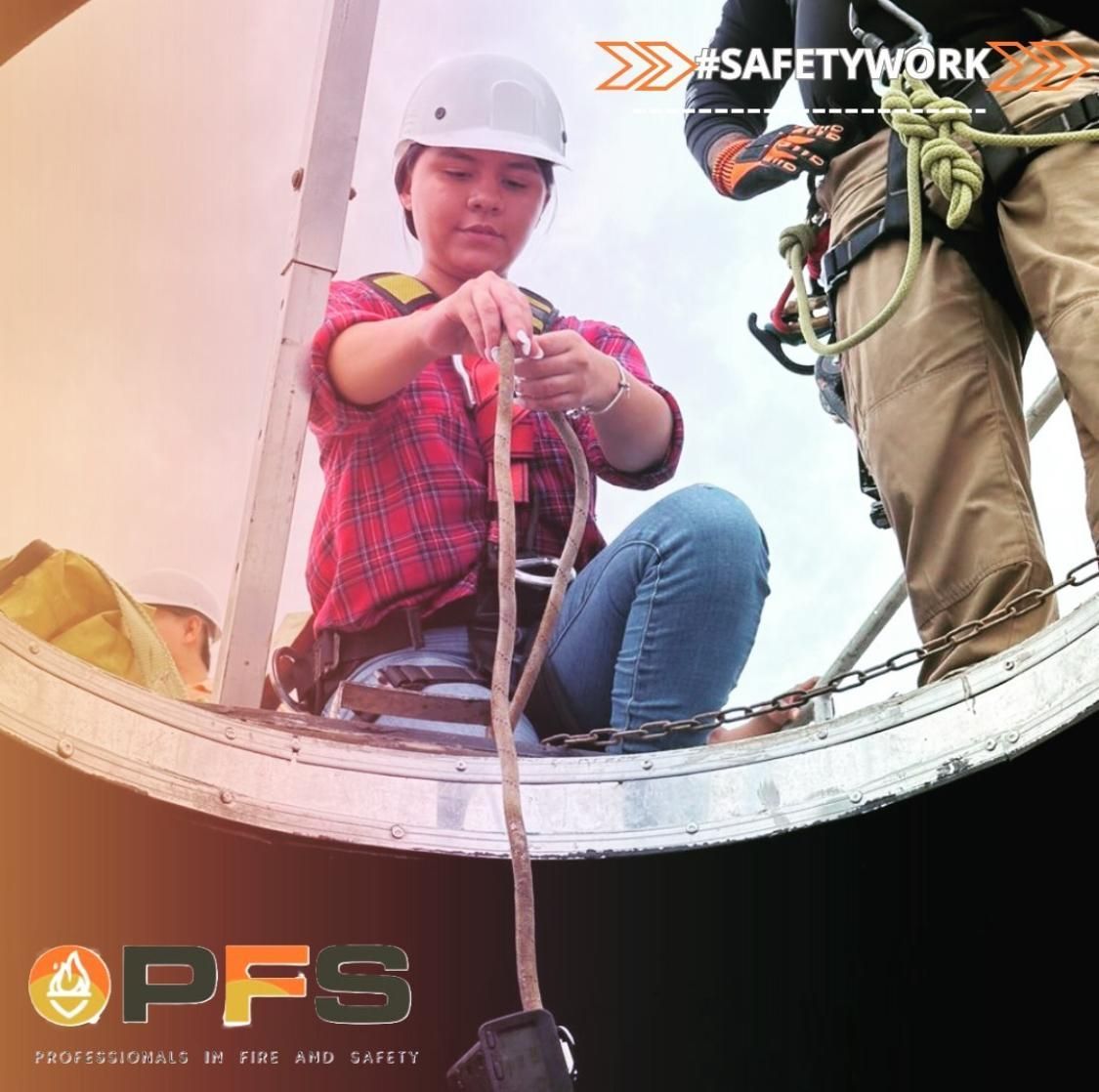 Una persona con equipo de seguridad, casco y arnés, conecta cuerdas sentada en una estructura metálica. El fondo muestra el logotipo #SafetyWork.