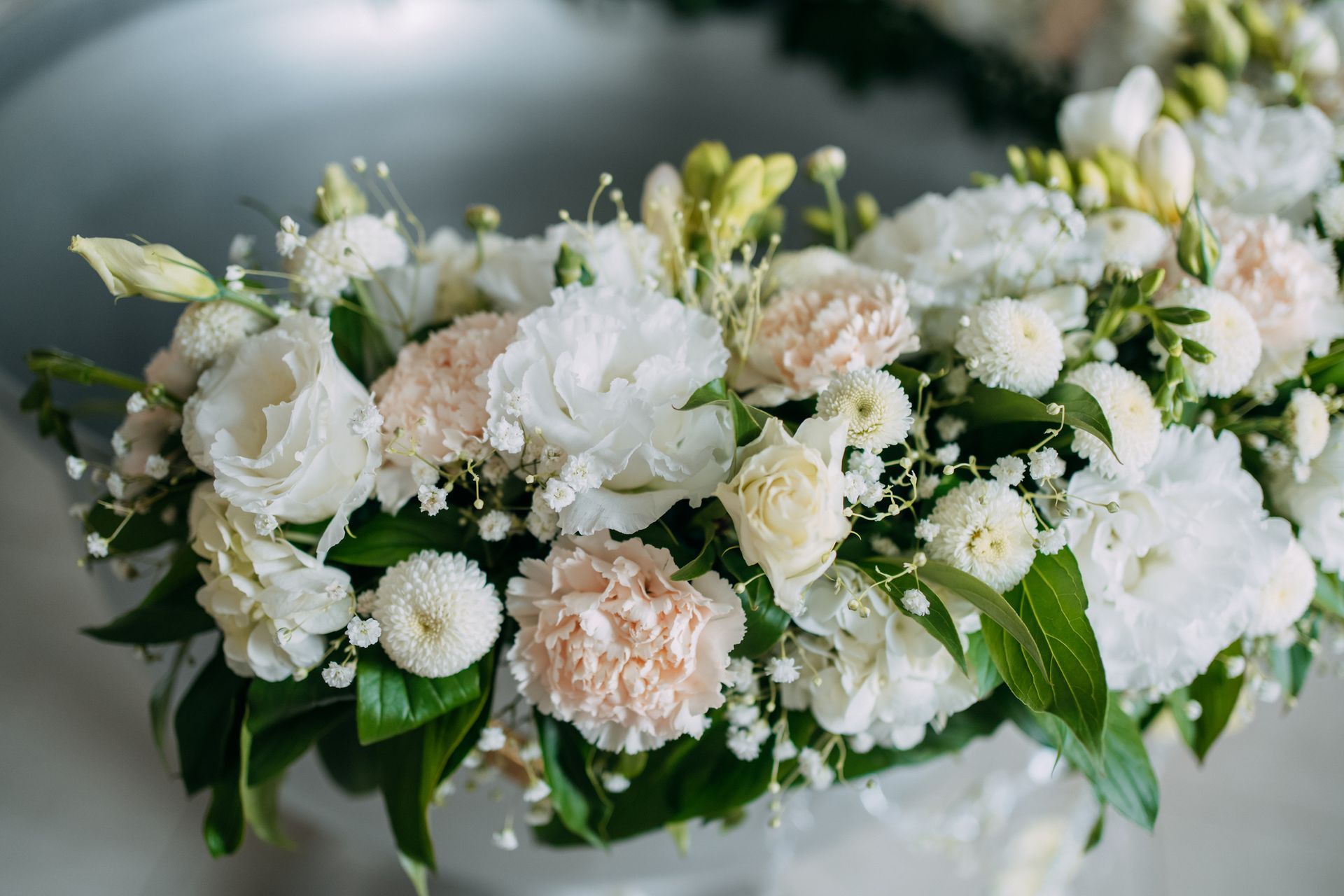 Una corona di fiori bianchi e gypsophila su un tavolo.