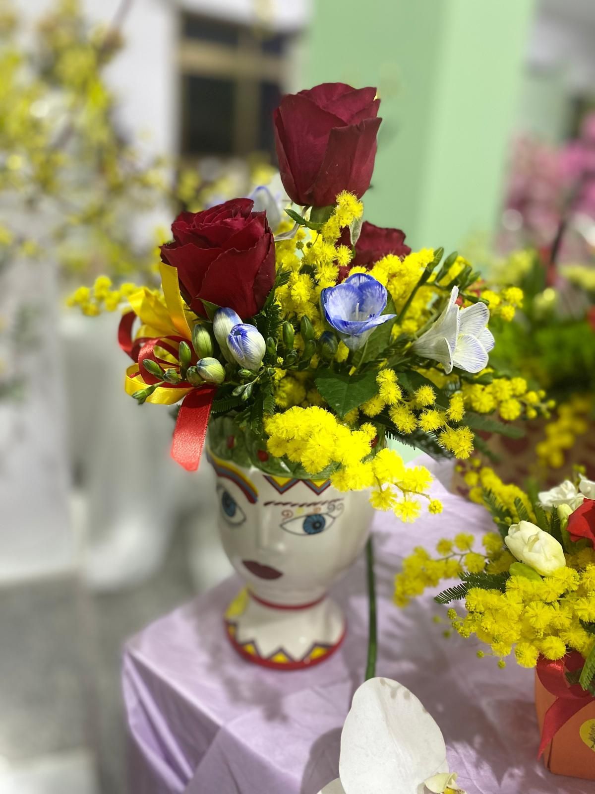 Una donna sta tagliando i fiori con le forbici su un tavolo.