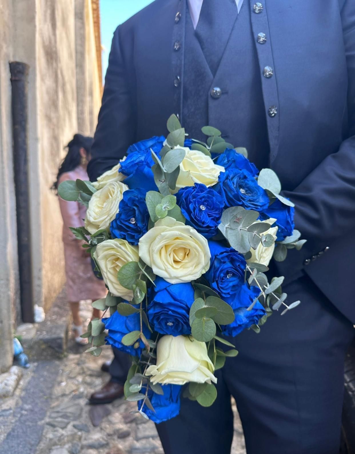 Una donna sta andando in bicicletta con un mazzo di fiori nel cestino.