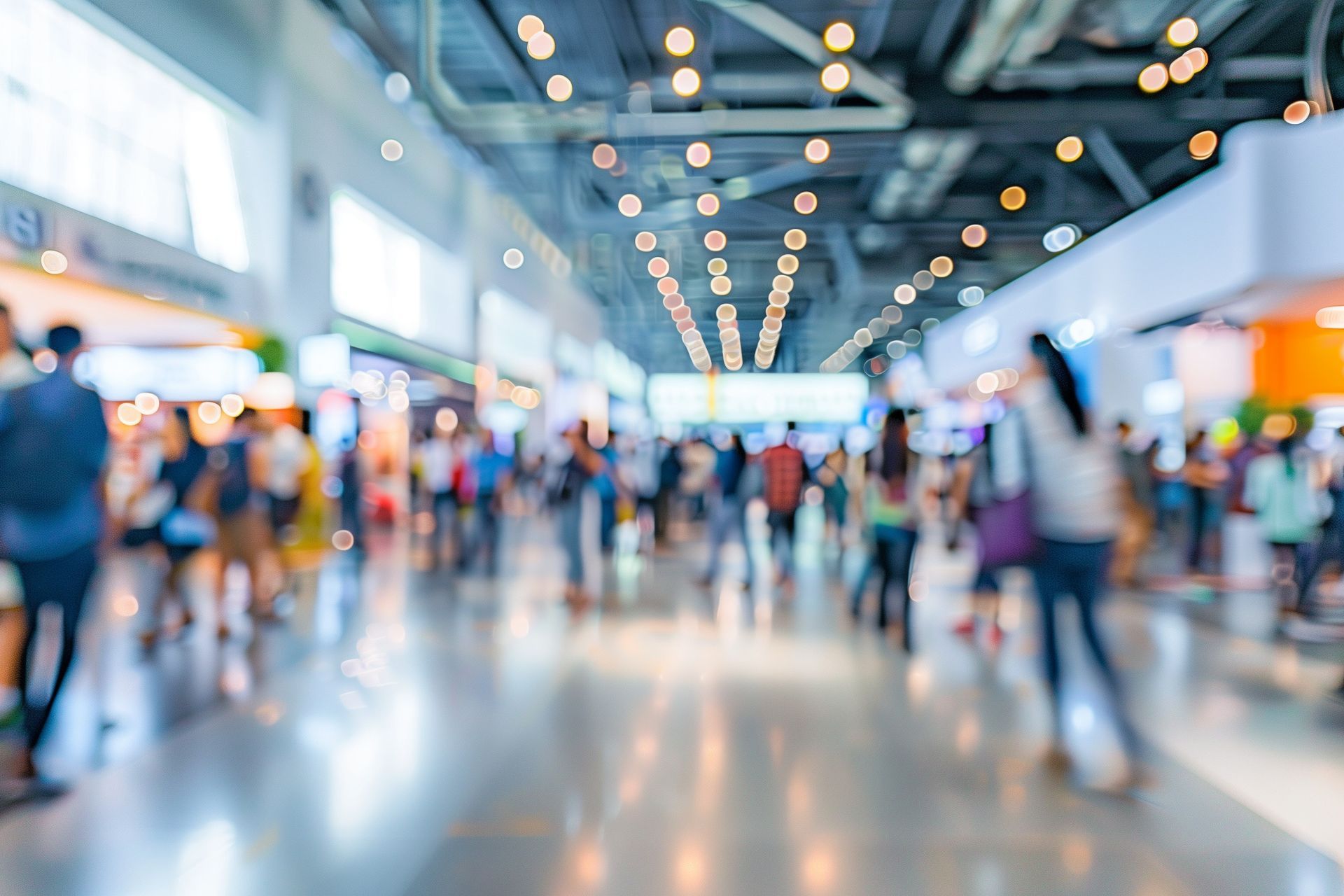 A blurry picture of a crowd of people walking in an airport.