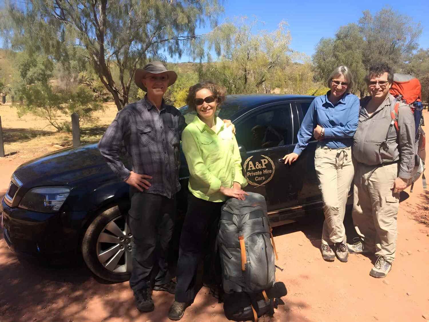 A Group Of People Are Posing For A Picture In Front Of A Car — A & P Private Hire In Sadadeen, NT