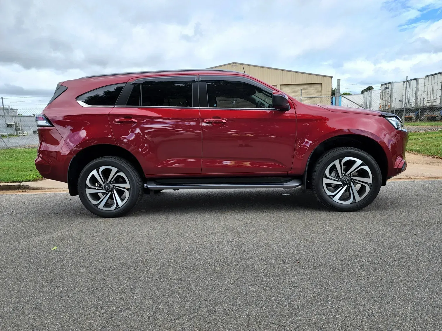 A Red SUV is Parked on the Side of the Road — Ace Tinting in Mareeba, QLD