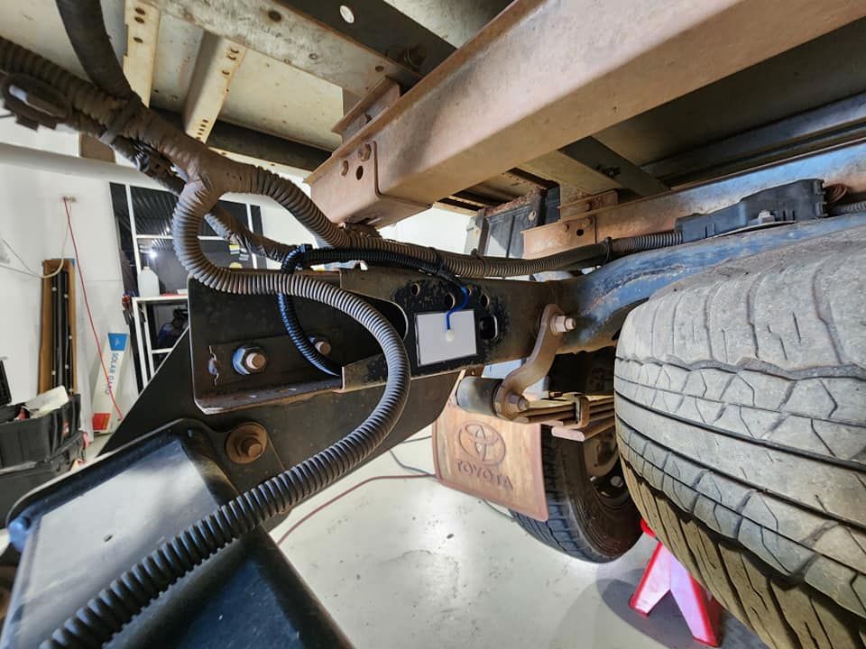 A Toyota Truck is Sitting on a Jack in a Garage — Ace Tinting In Port Douglas, QLD