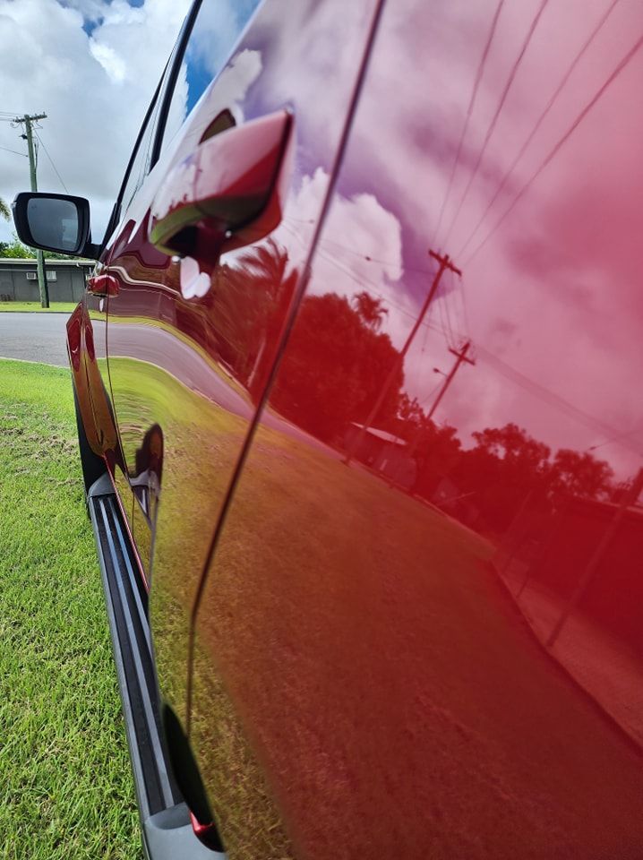 A Red Car is Parked on the Side of the Road — Ace Tinting in Mareeba, QLD