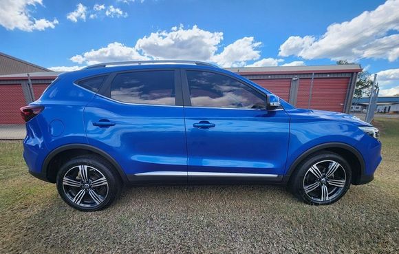 A Blue Car is Parked in a Gravel Lot in Front of a Building — Ace Tinting in Mareeba, QLD