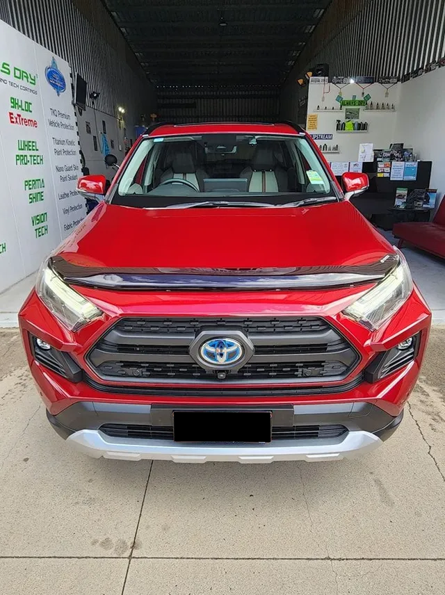 A Red Toyota RAV4 is Parked in Front of a Building — Ace Tinting In Cairns, QLD