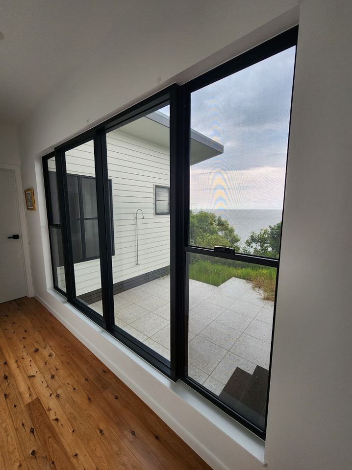 A large window in a room with a view of the ocean — Ace Tinting in Mareeba, QLD