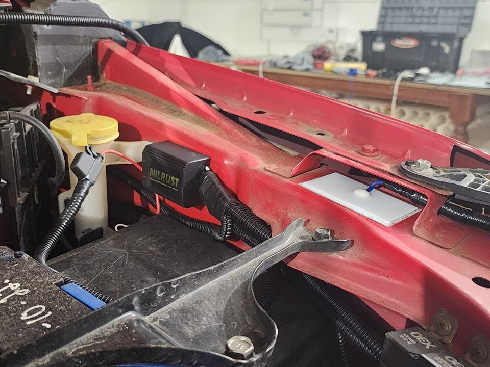 A red car is being worked on in a garage — Ace Tinting in Mareeba, QLD