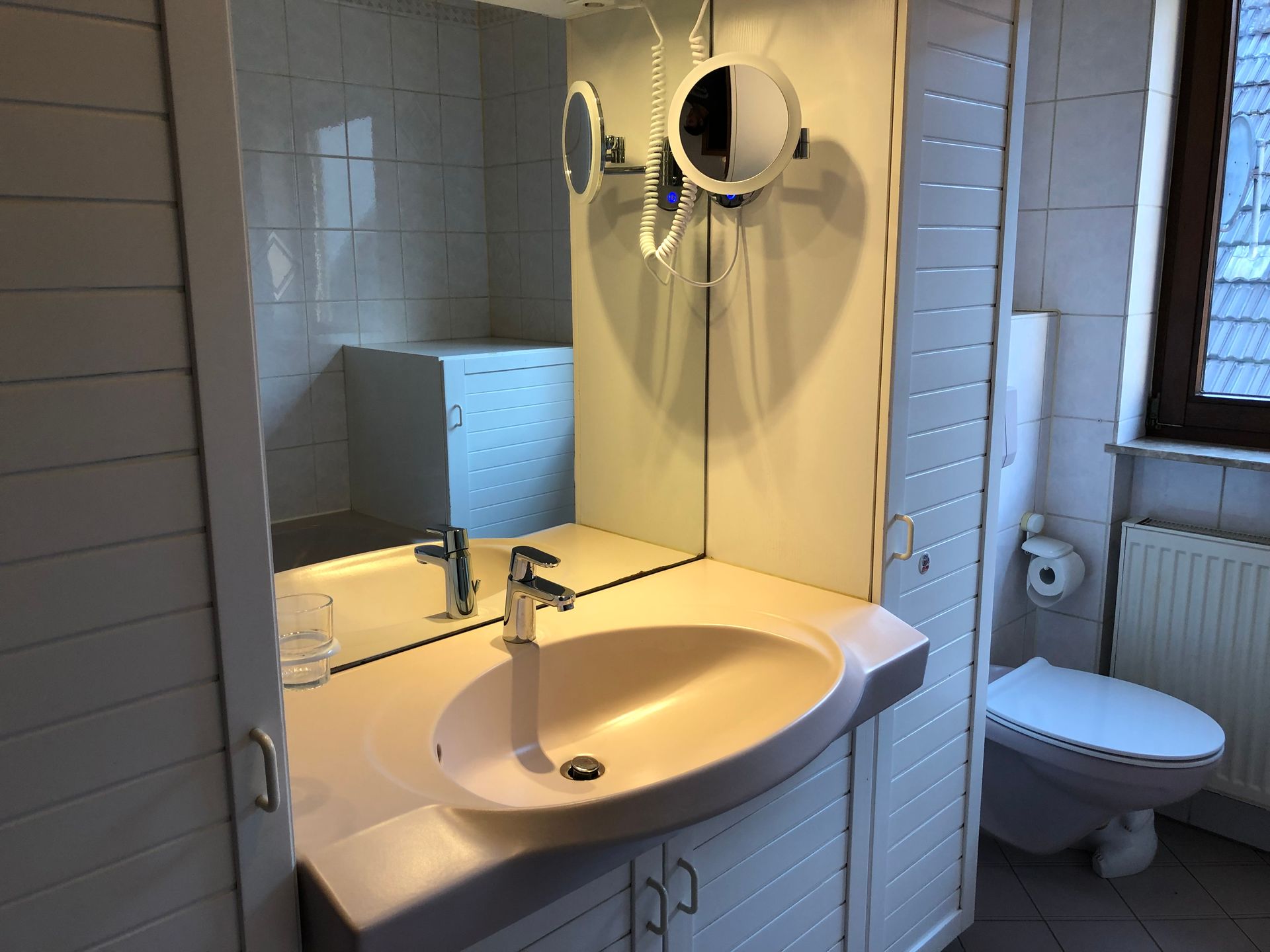 Ein Badezimmer mit Waschbecken, Toilette und Spiegel