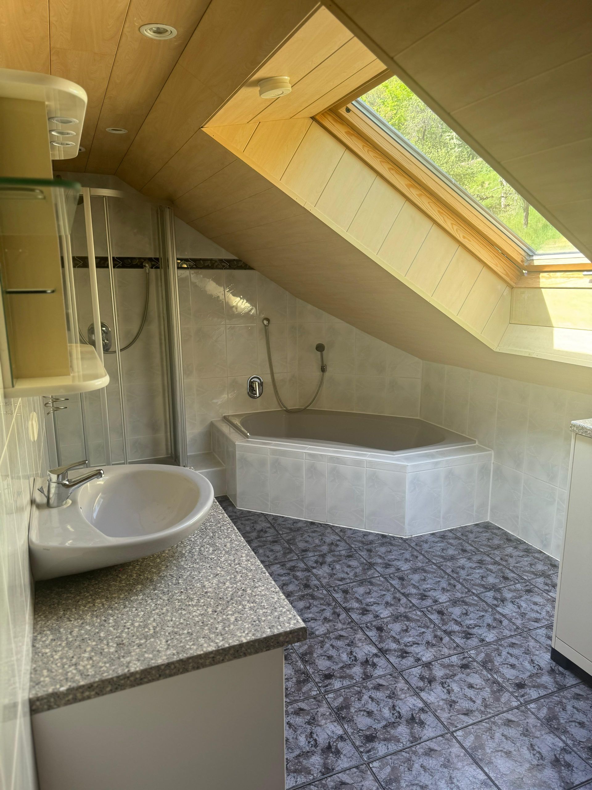 Ein Badezimmer mit Waschbecken, Badewanne und Oberlicht.