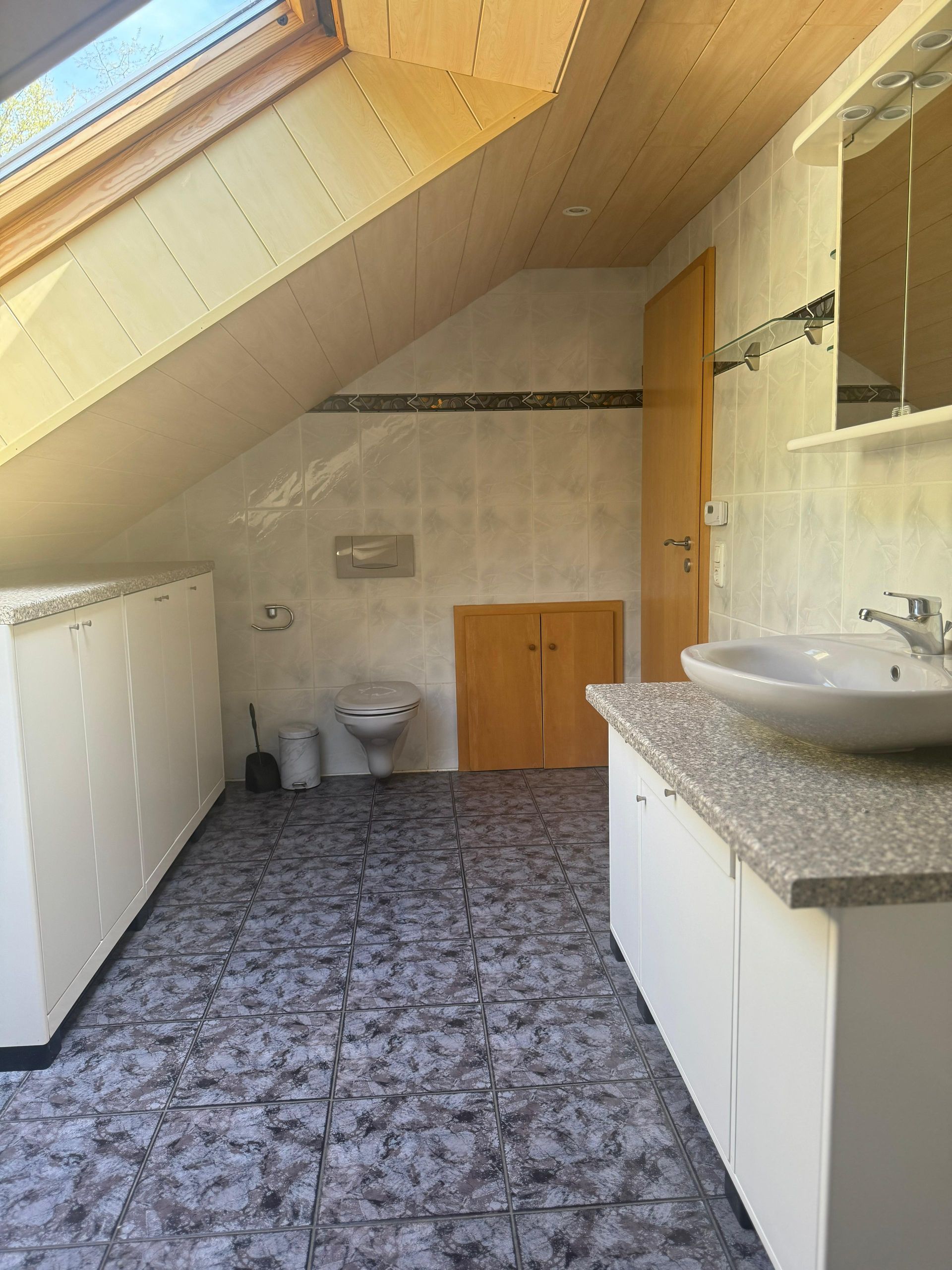 Ein Badezimmer mit Waschbecken, Toilette und Oberlicht.