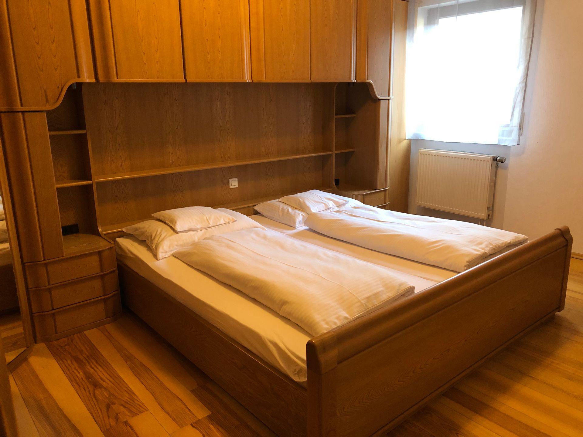 Ein Schlafzimmer mit einem Holzbett und einem Fenster