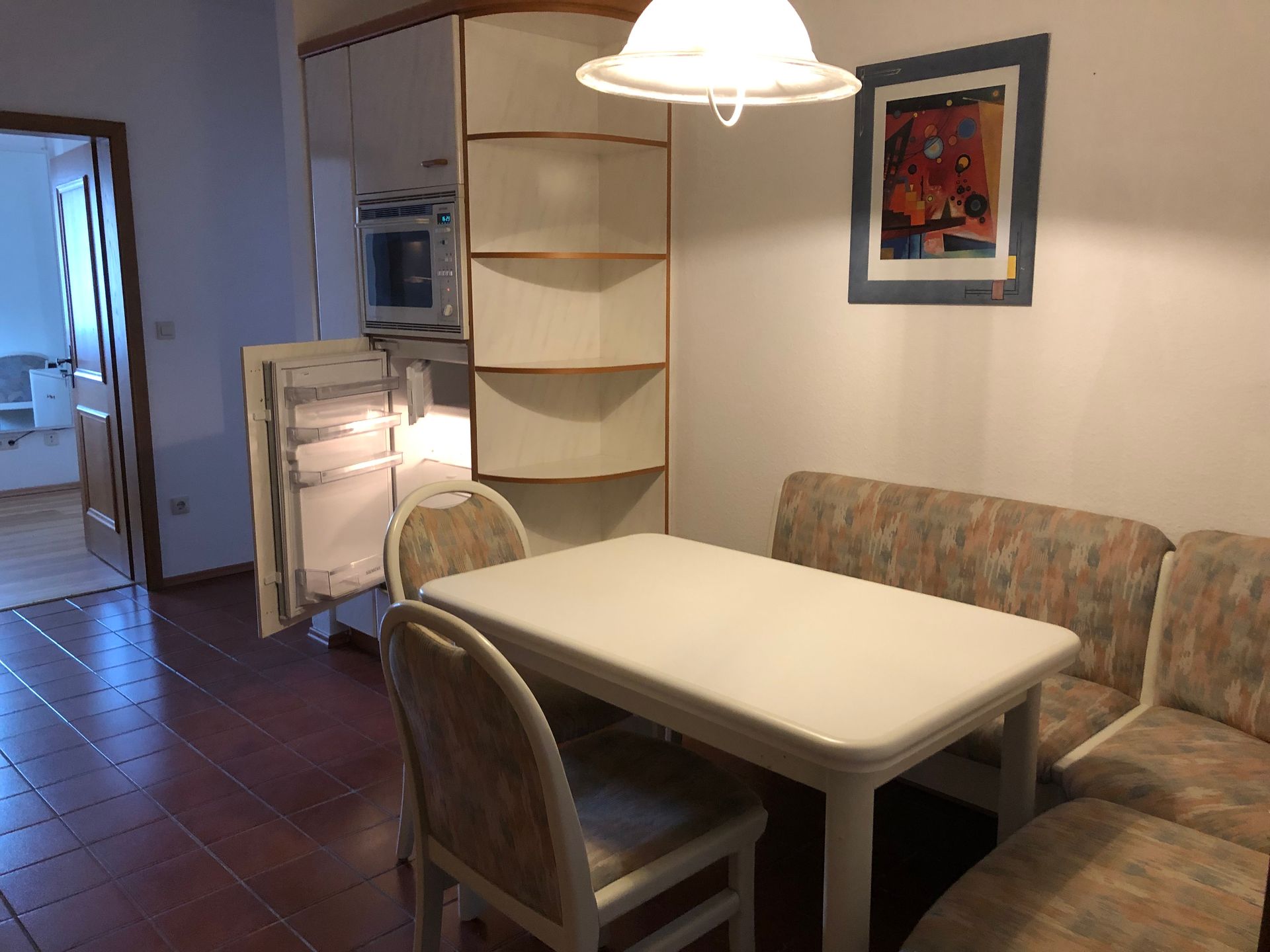 Eine Küche mit Tisch und Stühlen und einem Bild an der Wand