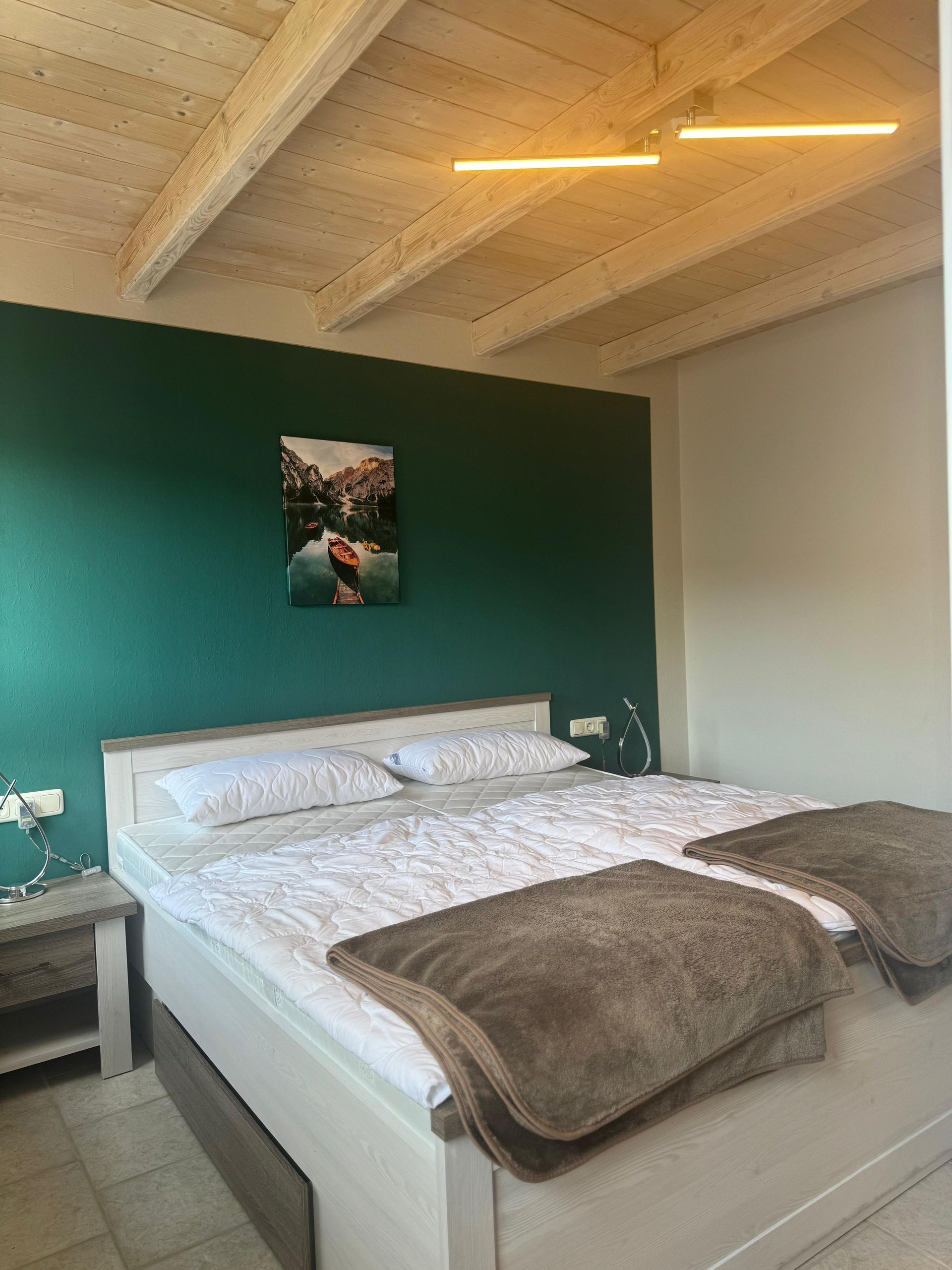 Ein Schlafzimmer mit einem Bett und einem Bild an der Wand.