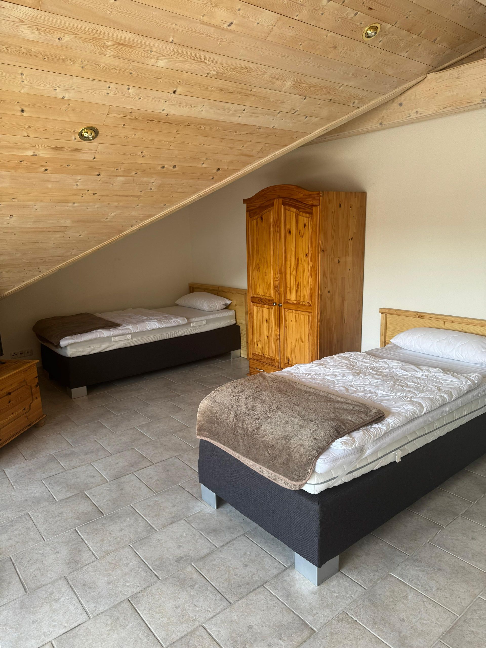 Ein Schlafzimmer mit zwei Betten und einem Holzschrank
