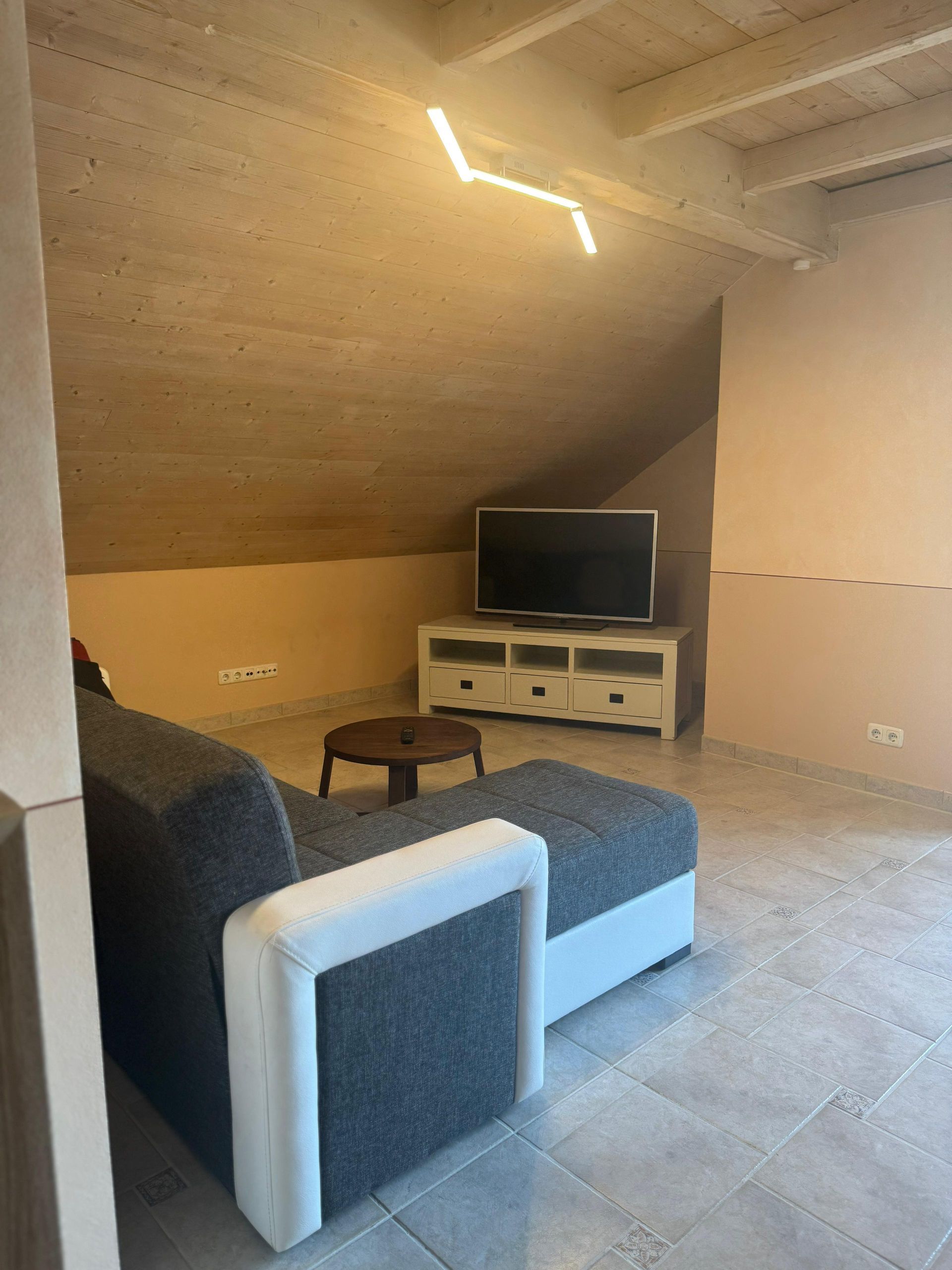 Ein Wohnzimmer mit Couch und Flachbildfernseher