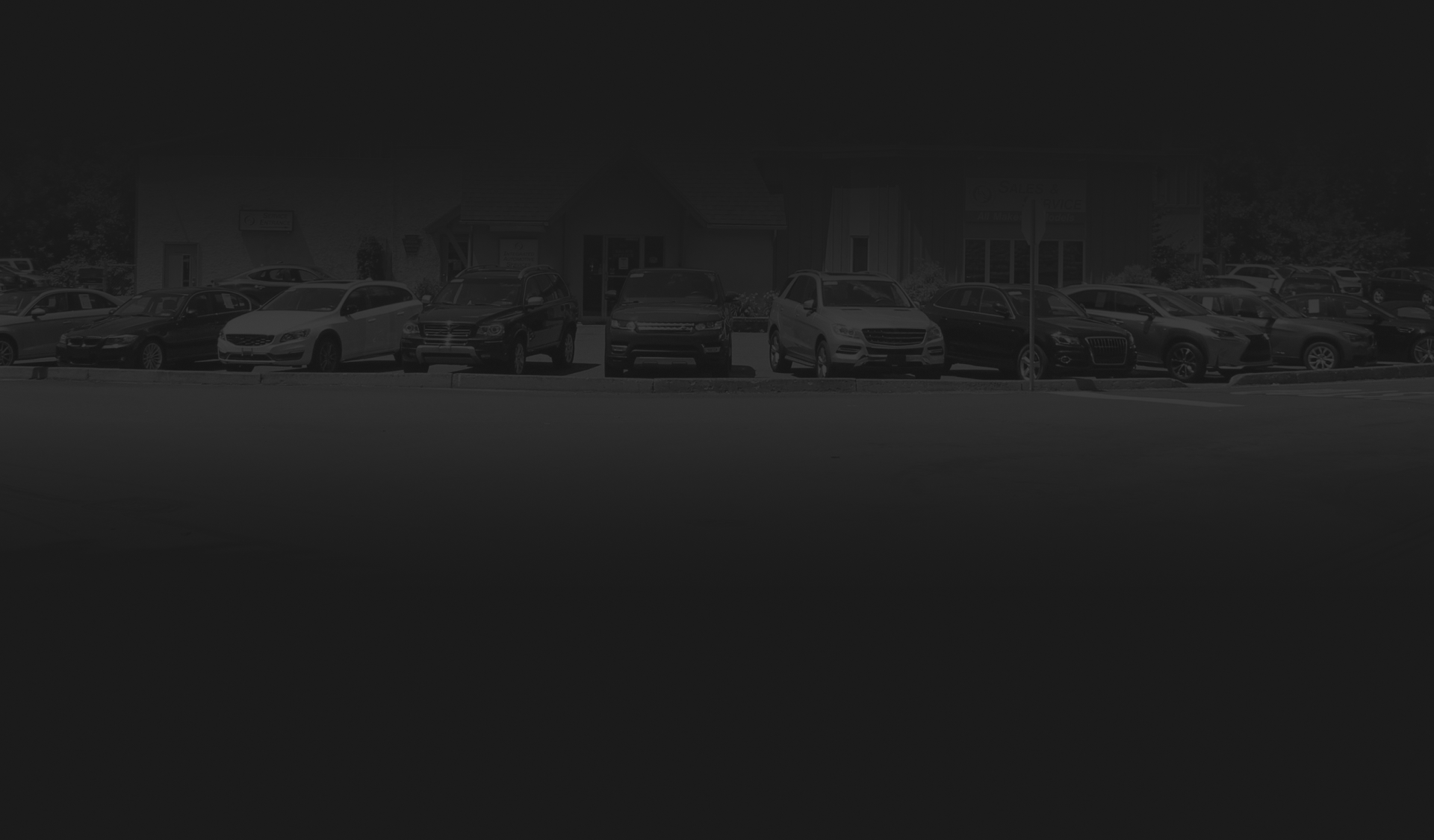 Dim parking lot with several parked cars and a darkened foreground. | Integrated Automotive Services
