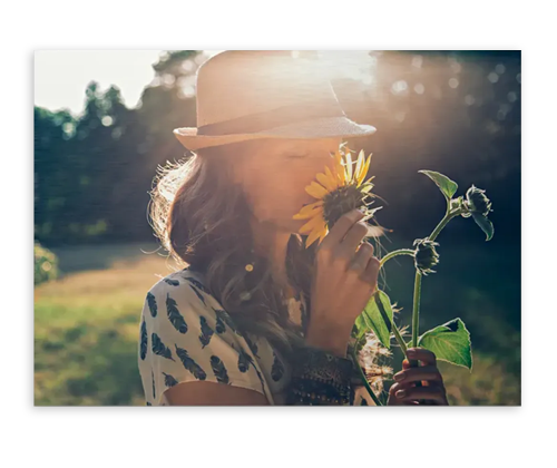 Poster of a woman smelling a flower