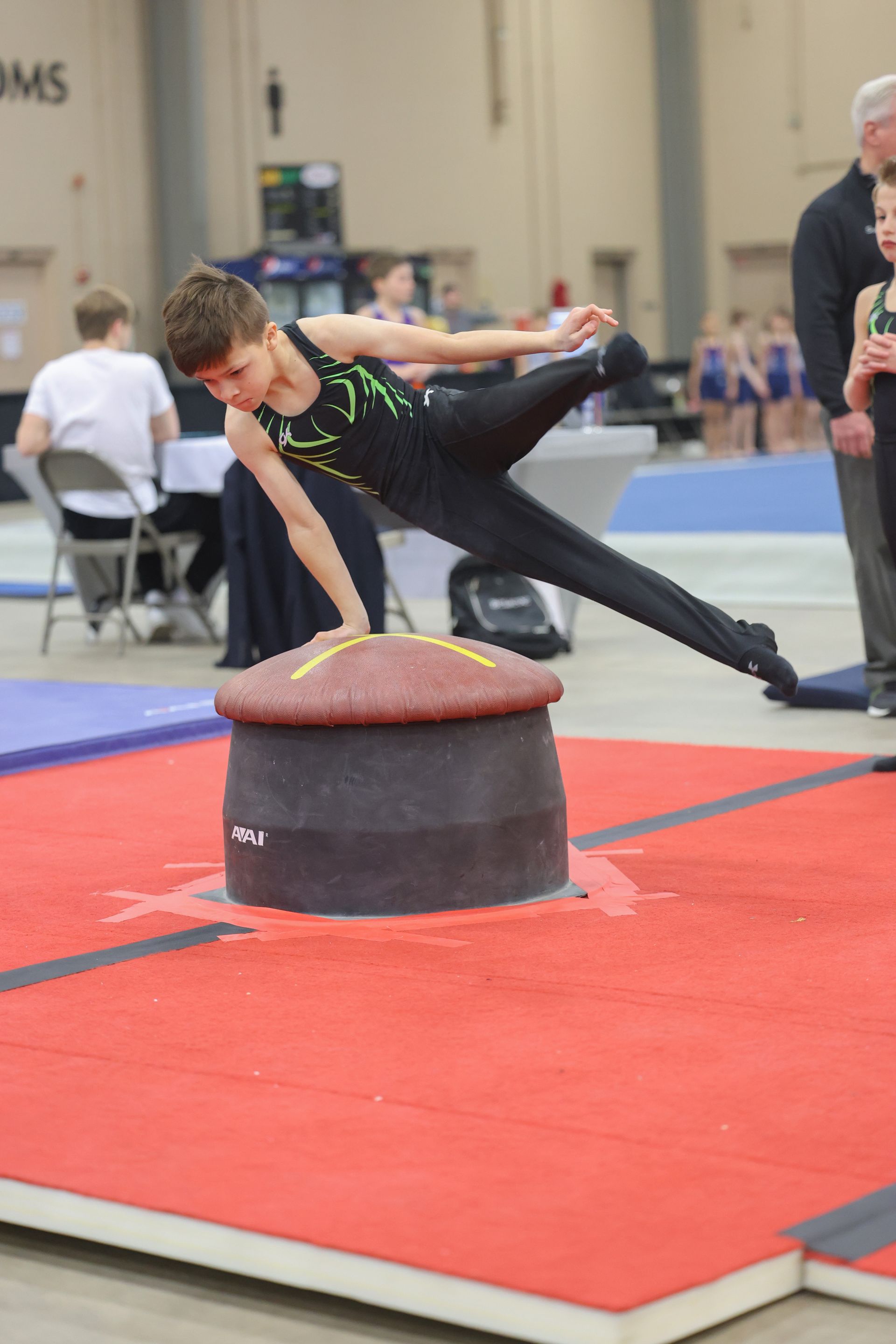 A young boy is doing a trick on a gymnastics mat.