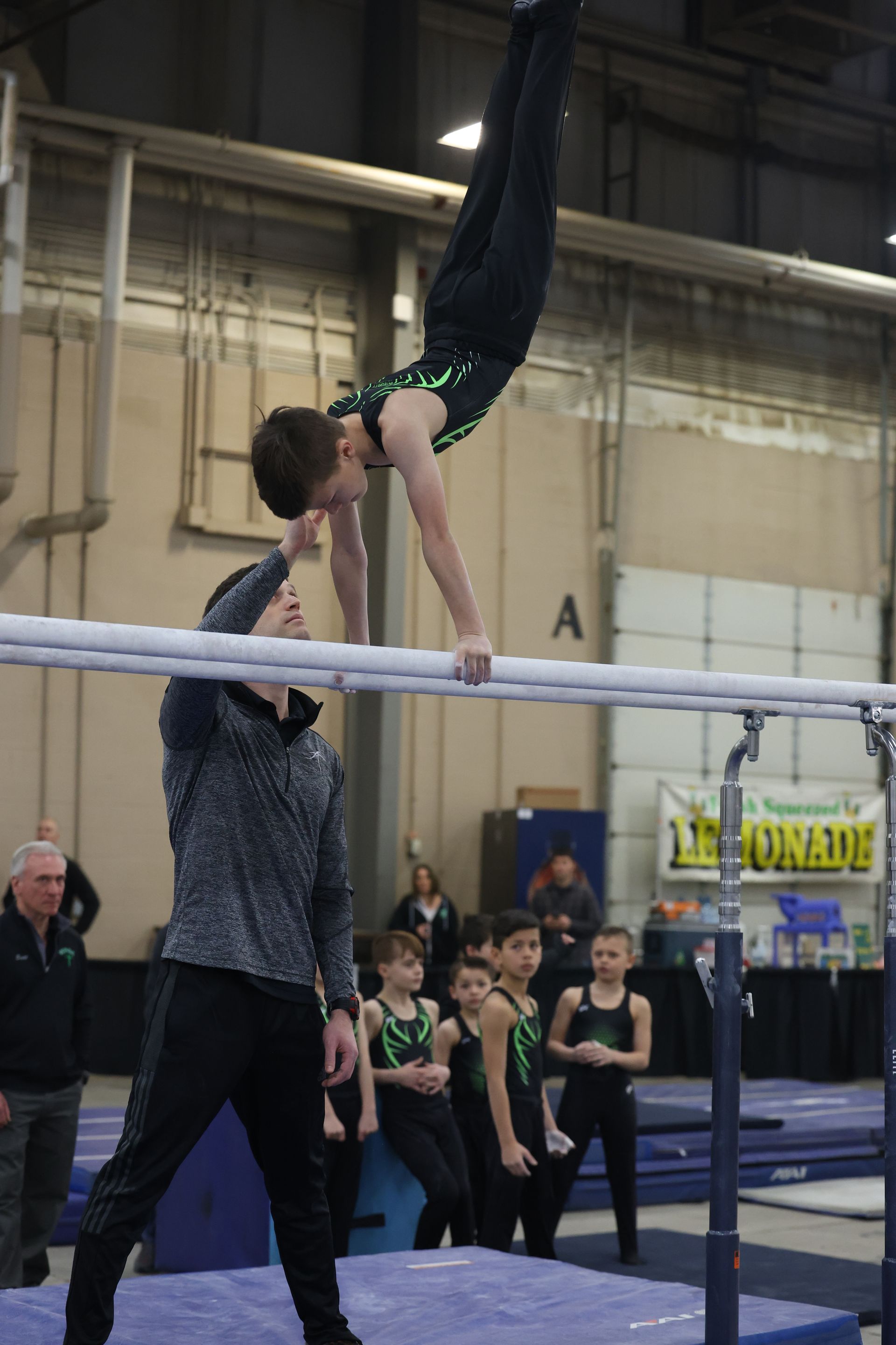 A gymnast is doing a handstand on a parallel bars