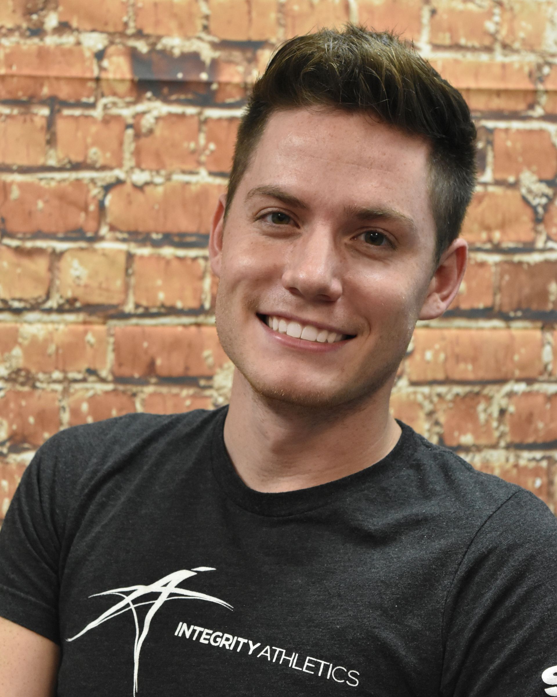 A man wearing a black shirt that says integrity athletics