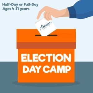 A hand is putting a ballot into an orange box that says election day camp