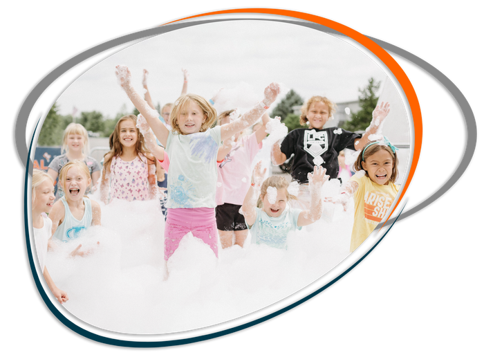 A group of children are jumping in the air while playing with foam.