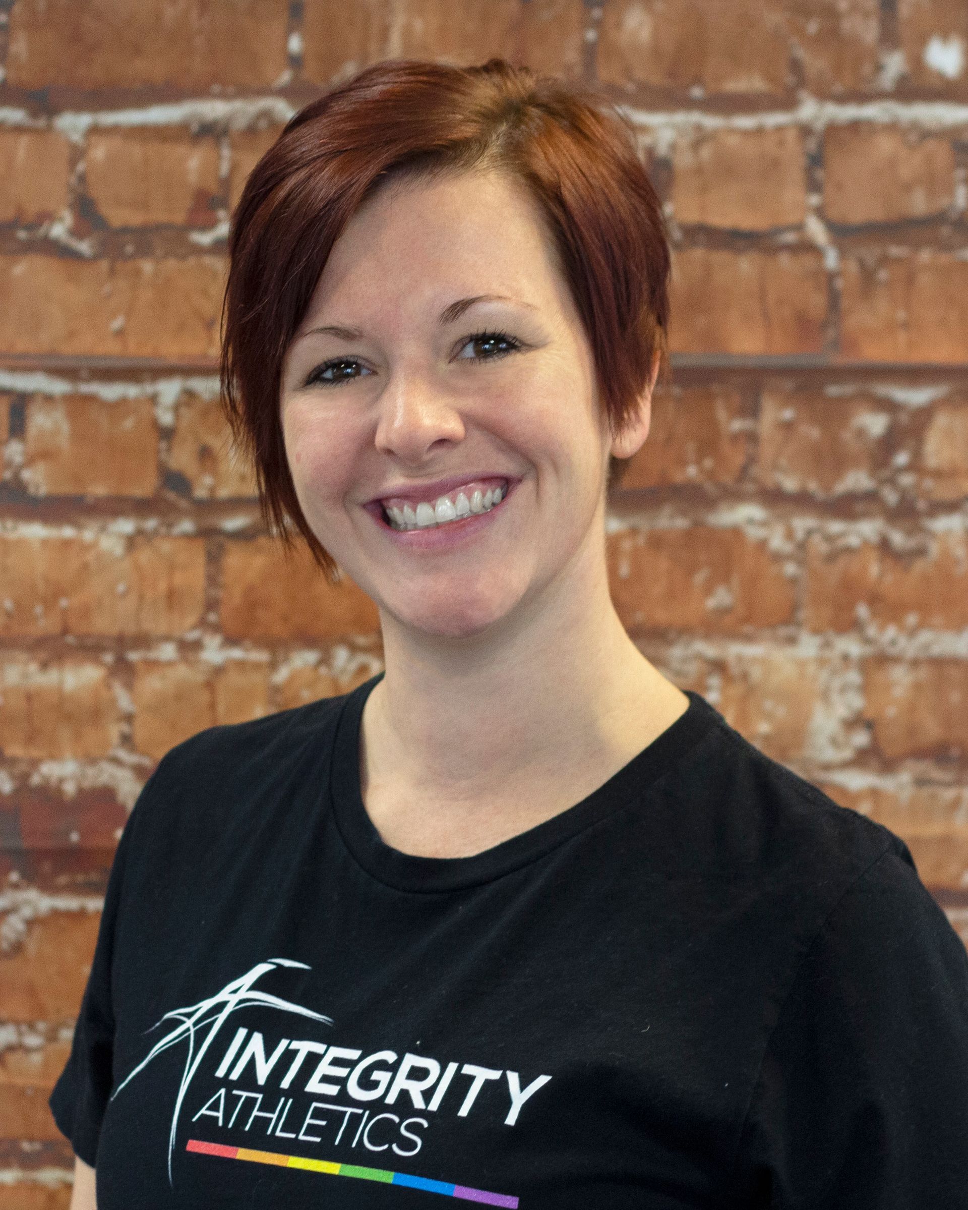 A woman wearing a black shirt that says integrity athletics