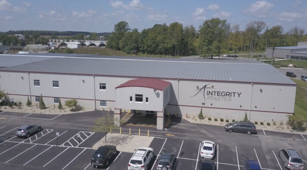 An aerial view of a large building with cars parked in front of it.